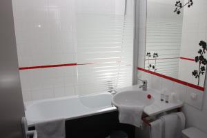 普雷讷夫昂德雷Motel du Val André的浴室配有白色浴缸、盥洗盆和浴缸。