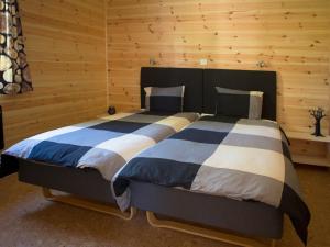 TivedHamgården Nature Resort Tiveden的木制客房内的一间卧室配有一张大床