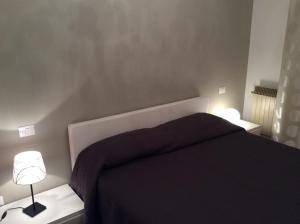 基安奇安诺泰尔梅Appartamento con Vista的一间卧室配有一张黑色的床和两盏灯。