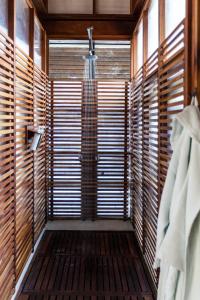 Isletas de GranadaJicaro Island Lodge Member of the Cayuga Collection的配有木制窗户的客房内的步入式淋浴间