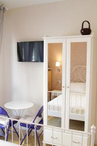 里米尼艾普罗普雷圣吉罗拉莫住宿加早餐旅馆的客房设有带桌椅的白色橱柜。