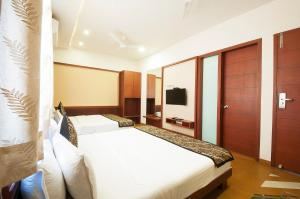 乌代浦Uddhav Vilas A Family Hotel的一间酒店客房,设有两张床和电视