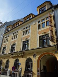 慕尼黑布伦霍夫酒店市中心店的黄色的建筑,旁边标有标志