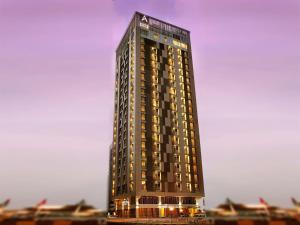 阿布扎比哈拉阿建罗塔纳豪华公寓酒店 的一座高大的建筑,旁边灯火通明
