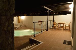 纳萨雷特Casa Alba的阳台设有游泳池、桌子和桌子。