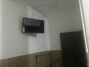 阿帕雷西达Pousada Tilu的墙上的平面电视