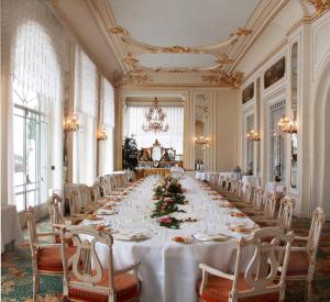 斯特雷萨Grand Hotel des Iles Borromées & SPA的长长的用餐室配有长桌子和椅子
