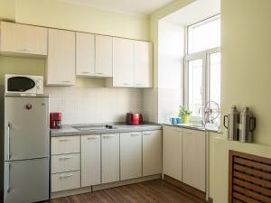 乌兰巴托扎雅旅馆的厨房配有白色橱柜和冰箱。