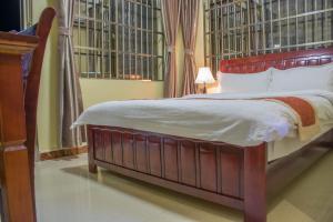 达累斯萨拉姆香港酒店的一间卧室配有一张大床和木制床头板