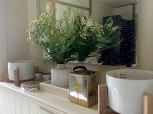 艾尔舍姆Tinsmiths House的浴室柜台上摆放着花瓶和鲜花