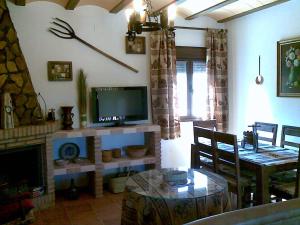 波索阿尔孔Casa Rural El Parral, Sierra Cazorla的一间带电视和餐桌的客厅