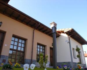 SelorioHotelapartamentos Torres的前面有一根杆和花的房子