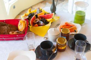 勒唐蓬La Résidence des Caféiers - Le Tampon的一张桌子,上面放着一盘食物和一碗水果