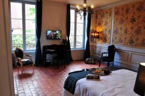 韦兹莱Les Glycines Vézelay的卧室配有一张床、一张书桌和窗户。