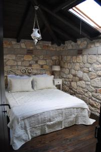 普萨克迪亚Halkidiki Luxurious Stonehouses的卧室配有一张石墙床