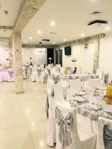 阿尔杰什河畔库尔泰亚Pensiune Matrix的宴会厅配有白色的桌子和白色的椅子