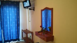 佩科霍里Hotel Flesvos的一间设有镜子的客房,墙上配有电视