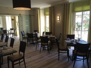沃尔特斯多夫科拉尼克斯博格餐厅酒店的用餐室设有桌椅和窗户。