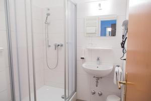 萨尔茨堡Salzburg Hotel Lilienhof的带淋浴和盥洗盆的白色浴室