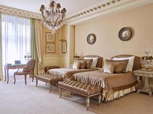 维也纳Grand Hotel Wien的一间卧室配有两张床和吊灯。