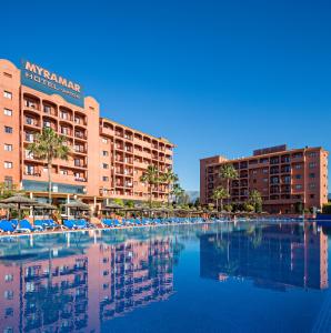 福恩吉罗拉ILUNION Miramar的酒店设有带椅子的游泳池,拥有建筑