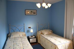 萨利纳斯Sierra Pulide Apartamentos的蓝色墙壁客房的两张床