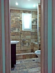 尼亚普拉莫斯Iro Apartment的带淋浴、盥洗盆和卫生间的浴室