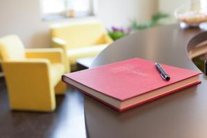 柏林米特-门施酒店的一张红色笔记本,放在桌子上,用笔写着