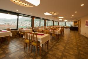 阿马西亚阿明酒店 的餐厅设有桌椅和大窗户。