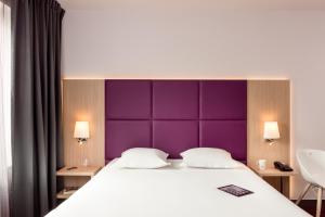 马拉科夫巴黎马拉科夫查狄伦公寓式酒店的一间卧室配有一张大床和紫色床头板