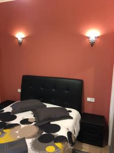 波尔多波尔多圣米歇尔公寓的一间卧室设有黑色的床和橙色的墙壁。