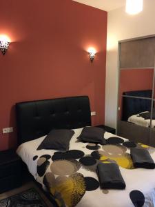 波尔多波尔多圣米歇尔公寓的一间卧室配有一张带黑色床头板和镜子的床