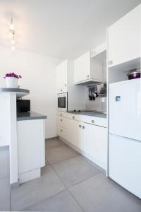 帕特里莫尼奥Studio Marine du Soleil的白色的厨房配有白色橱柜和电器