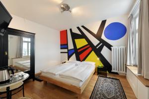 伯尔尼伯尔尼国家饭店的卧室配有一张床,墙上挂有绘画作品
