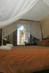 瓦莱塔卢西亚诺瓦尔塔精品酒店的一间卧室配有一张带橙色床罩的床