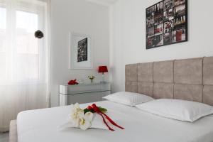 斯普利特卡拉卡雷塔公寓的卧室配有白色的床,床上有花