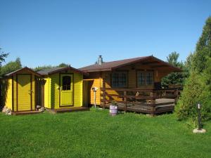 KolkjaKolkja Holiday Centre的草上的一个黄色房子,有院子