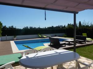 桑特佩尔佩斯卡多尔Belvilla by OYO Bon Relax II45的一个带桌椅的庭院和一个游泳池
