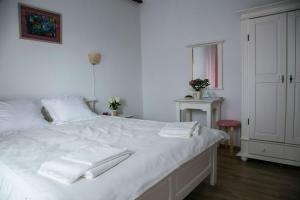 Budeasa MicăPensiunea Margareta的卧室配有白色床和毛巾