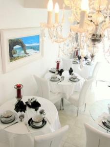 斯瓦科普蒙德卵石旅馆的用餐室配有白色桌椅和吊灯。