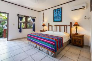 西区Splash Inn Dive Resort & Villas的一间卧室配有一张床、一张桌子和一个窗户。