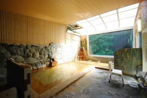 贝冢市奥水間温泉酒店的客房设有大窗户和水族馆