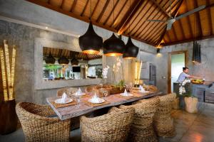 坎古伊帕内玛巴厘岛别墅的一间带桌子和藤椅的用餐室