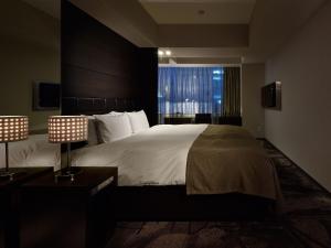 东京格兰贝尔酒店的一间卧室设有一张大床和大窗户