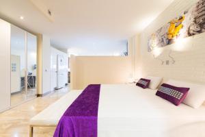 大加那利岛拉斯帕尔马斯毕加索花园阁楼公寓的卧室配有一张大白色床和紫色床单
