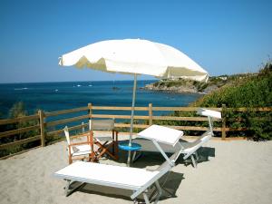 利沃诺米拉马尔酒店的海滩上的两把椅子和一把遮阳伞