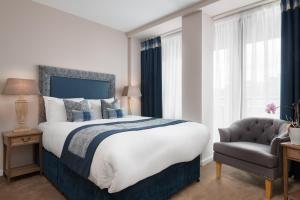 爱丁堡BDL王子大街套房酒店的一间卧室配有一张大床和一把椅子