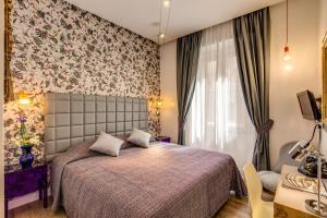 罗马帕拉门托精品酒店的一间卧室设有一张床和花卉墙