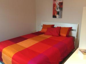 BerbourgVakantieverblijf Luxemburg的一张带彩色条纹床罩的床