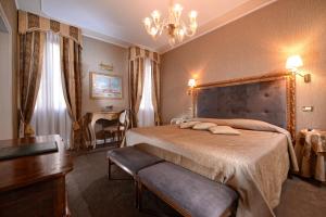 威尼斯圣塔马丽娜酒店的一间卧室配有一张床、一张桌子和一个吊灯。